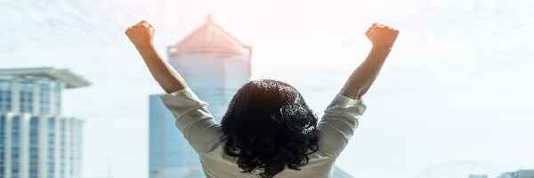 Woman celebrating victory overlooking city