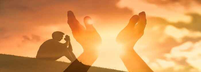 Man on a grassy slope praying, looking to heaven quoting powerful prayers 