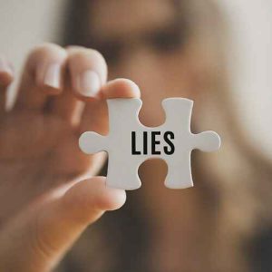 Woman holding puzzle piece with word "lies," Conquering Deception.