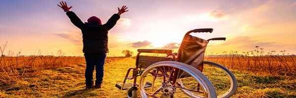 A man standing praising God in front of his empty wheelchair after a miraculous intercession.